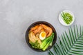 Asian noodle soup, ramen with prawn shrimp, vegetables and egg in black bowl on gray concrete background. Flat lay, Top view, mock Royalty Free Stock Photo