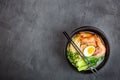 Asian noodle soup, ramen with prawn shrimp, vegetables and egg in black bowl on gray concrete background. Flat lay, Top view, mock Royalty Free Stock Photo