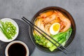 Asian noodle soup, ramen with prawn shrimp, vegetables and egg in black bowl on gray concrete background. Flat lay, Top view, mock Royalty Free Stock Photo