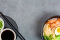 Asian noodle soup, ramen with prawn shrimp, vegetables and egg in black bowl on gray concrete background. Flat lay, Top view, mock Royalty Free Stock Photo