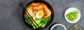 Asian noodle soup, ramen with prawn shrimp, vegetables and egg in black bowl on gray concrete background. Flat lay, Top Royalty Free Stock Photo