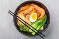 Asian noodle soup, ramen with prawn shrimp, vegetables and egg in black bowl on gray concrete background. Flat lay, Top Royalty Free Stock Photo