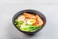 Asian noodle soup, ramen with prawn shrimp, vegetables and egg in black bowl on gray concrete background. Flat lay, Top Royalty Free Stock Photo