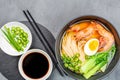 Asian noodle soup, ramen with prawn shrimp, vegetables and egg in black bowl on gray concrete background. Flat lay, Top Royalty Free Stock Photo