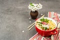 Asian noodles with chicken, vegetables, and herbs in a red bowl. Traditional Japanese soup Royalty Free Stock Photo