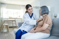 Asian nurse at nursing home take care of disabled senior elderly woman. Beautiful therapist doctor measure heart rate by