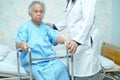 Asian nurse physiotherapist doctor care, help and support elderly old woman patient with walker. Royalty Free Stock Photo