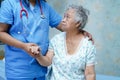 Asian nurse physiotherapist doctor care, help and support senior or elderly old lady woman patient lie down in bed at hospital war Royalty Free Stock Photo