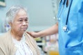 Asian nurse physiotherapist doctor care, help and support senior or elderly old lady woman patient lie down in bed at hospital war Royalty Free Stock Photo