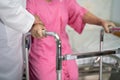 Asian nurse physiotherapist doctor care, help and support senior or elderly old lady woman patient walk with walker at hospital Royalty Free Stock Photo