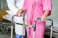 Asian nurse physiotherapist doctor care, help and support senior or elderly old lady woman patient walk with walker at hospital Royalty Free Stock Photo