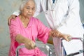 Asian nurse physiotherapist doctor care, help and support senior or elderly old lady woman patient walk with walker at hospital Royalty Free Stock Photo