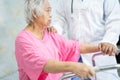 Asian nurse physiotherapist doctor care, help and support senior or elderly old lady woman patient walk with walker at hospital Royalty Free Stock Photo
