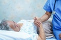 Asian nurse physiotherapist doctor care, help and support senior or elderly old lady woman patient lie down in bed at hospital war Royalty Free Stock Photo