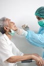 Asian nurse in protective suite taking a swab for nasal mucus test sample from old elderly patient,medical examination COVID-19 Royalty Free Stock Photo