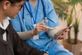 Asian nurse showing health checkup report to older and giving advice. Home nursing and healthcare caregiver concept Royalty Free Stock Photo