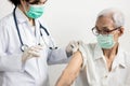 Asian nurse use cotton ball with alcohol to clean the shoulder of old elderly before vaccination Coronavirus,female doctor holding Royalty Free Stock Photo