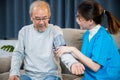 Asian nurse visit patient senior man at home she measuring arterial blood pressure on arm Royalty Free Stock Photo