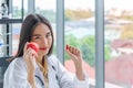 Asian nutritionist doctor woman showing red apple and soft gelatin capsule of food supplements Royalty Free Stock Photo