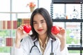 Asian nutritionist doctor woman showing red heart and apple in hand Royalty Free Stock Photo