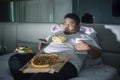 Asian obese man eating junk foods before sleep Royalty Free Stock Photo