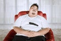 Asian obese man taking a nap on the sofa