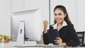 Asian office people are businesswoman wearing black suit using tablet instead computer at work desk look to feel happy with smile Royalty Free Stock Photo