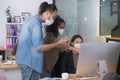 Asian office workers wearing face masks working in new normal office and doing social distancing Royalty Free Stock Photo