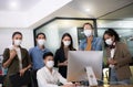 Asian office workers wearing face masks working in new normal office and doing social distancing Royalty Free Stock Photo