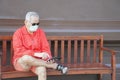 Asian old elder senior man wearing face mask elderly using mobile smart phone cellphone. mature retirement lifestyle Royalty Free Stock Photo