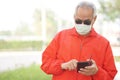 Asian old elder senior man wearing face mask elderly using mobile smart phone cellphone. mature retirement lifestyle Royalty Free Stock Photo
