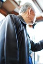 Asian old man elderly male senior holding handle in tram in Hong Kong shoulders