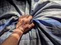 Asian old man hand holding blue cloth with beautiful pattern Royalty Free Stock Photo