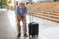 Asian old man, having knee injury on both sides, on the train station While he was traveling