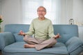 Asian old man practise yoga and meditation in lotus position and closed eyes Royalty Free Stock Photo