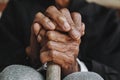 Asian old man sitting with his hands on a walking stick Royalty Free Stock Photo