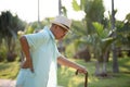 Asian old man walking in park and having a back pain, backache. Senior healthcare concept Royalty Free Stock Photo