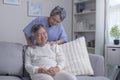 Asian old senior elderly husband sitting on sofa having problem with suffer backache painful shoulder