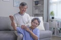 Asian old senior elderly wife sitting on floor having problem with suffer backache painful shoulder