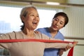 Asian old woman exercising using resistance band in rehab center Royalty Free Stock Photo