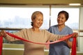 Asian old woman exercising using resistance band in rehab center