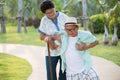 Asian old woman helping an elderly man having having a pain on heart, heart attack in a park. Senior healthcare concept Royalty Free Stock Photo