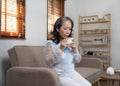 Asian old woman sipping tea in living room at home Royalty Free Stock Photo