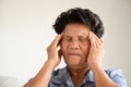 Asian old woman sitting on sofa and having a headache at home. Senior healthcare concept Royalty Free Stock Photo