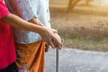 Asian old woman standing with her hands on a walker with daughter& x27;s hand,Hand of old woman holding a staff cane for helping Royalty Free Stock Photo