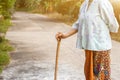 Asian old woman standing with her hands on a walking stick ,Hand of old woman holding a bamboo cane stick for helping walking Royalty Free Stock Photo