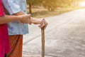 Asian old woman standing with her hands on a walking stick ,Hand of old woman holding a bamboo cane stick for helping walking Royalty Free Stock Photo