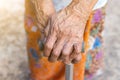 Asian old woman standing with her hands on a walking stick ,Hand of old woman holding a staff cane for helping walking Royalty Free Stock Photo