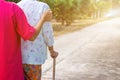 Asian old woman standing with her hands on a walking stick ,Hand of old woman holding a staff cane for helping walking Royalty Free Stock Photo