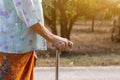 Asian old woman standing with her hands on a walking stick ,Hand of old woman holding a staff cane for helping walking Royalty Free Stock Photo